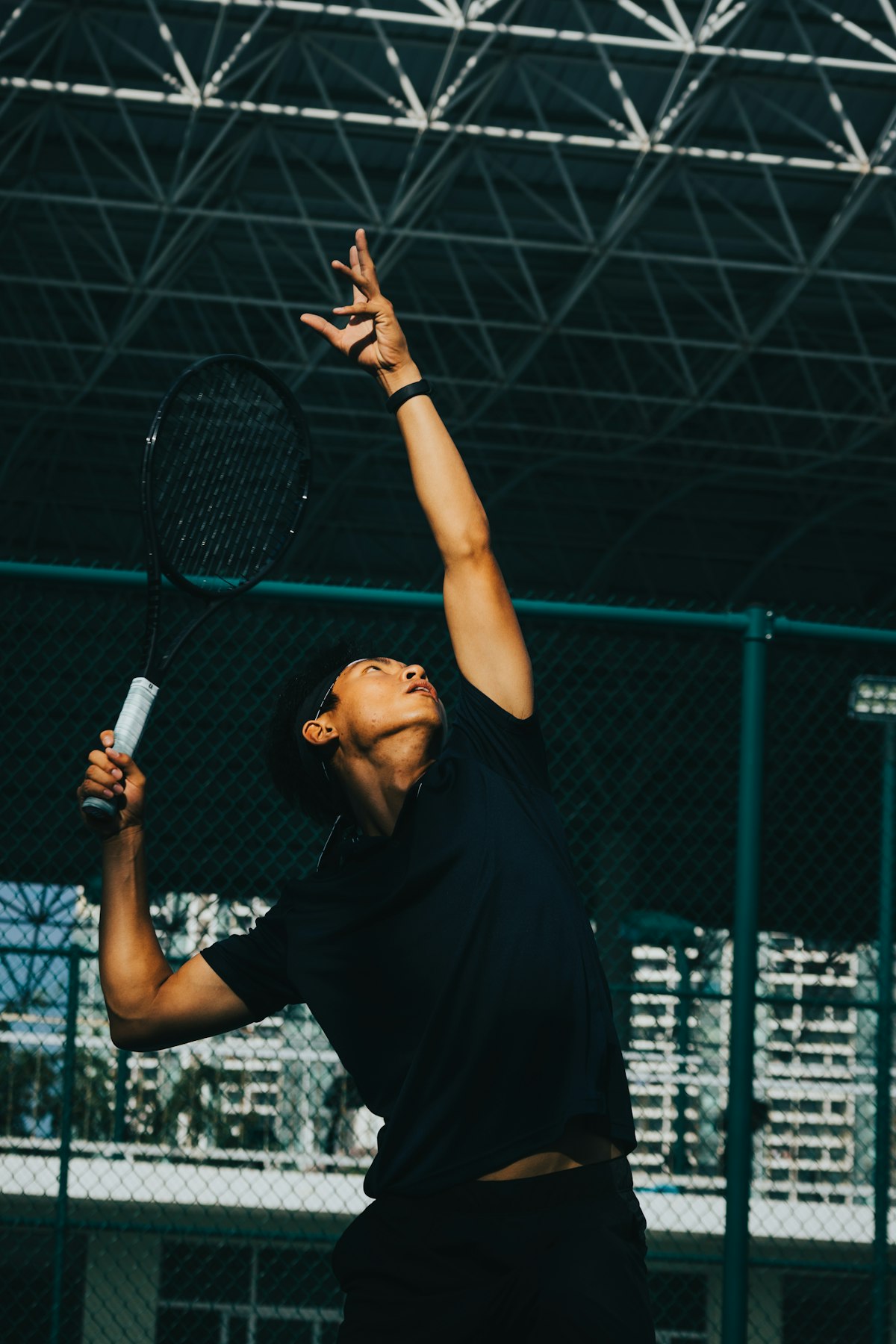 A tennis player holding a racket on court at golden hour